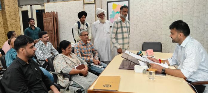 DM Dr Kuldeep Singh hearing public grievances during a Samadhan Shivir in Vyasapur.