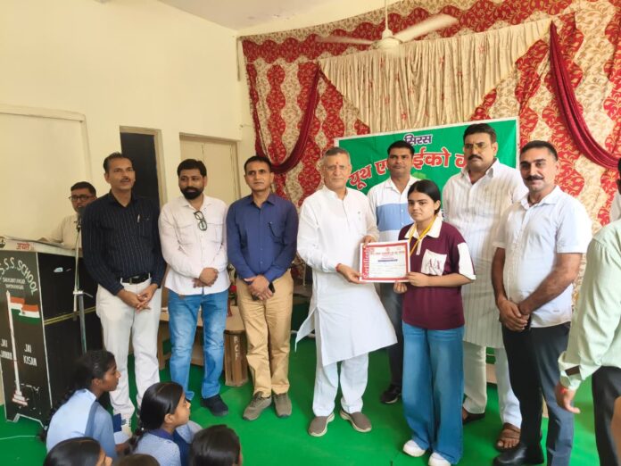 Kanwar Pal presenting medals and certificates to CBSE toppers during a felicitation ceremony at Saraswati Nagar school.